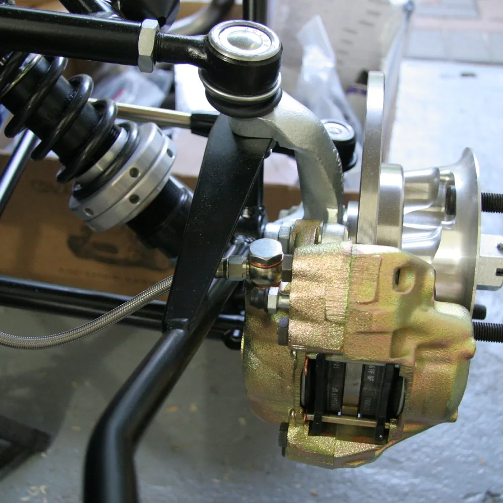 Brake caliper and brake lines being fitted on a car
