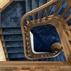 A stair detail in a Bucharest house, turned balusters and a newel post seen from the landing. An interior, not a photograph of a member of staff.