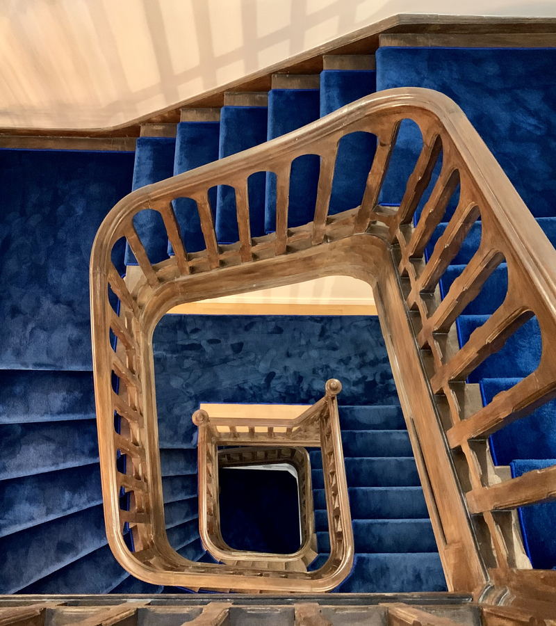 A landing at the head of a staircase, with panelled doors off it and a moulded cornice running round the ceiling.