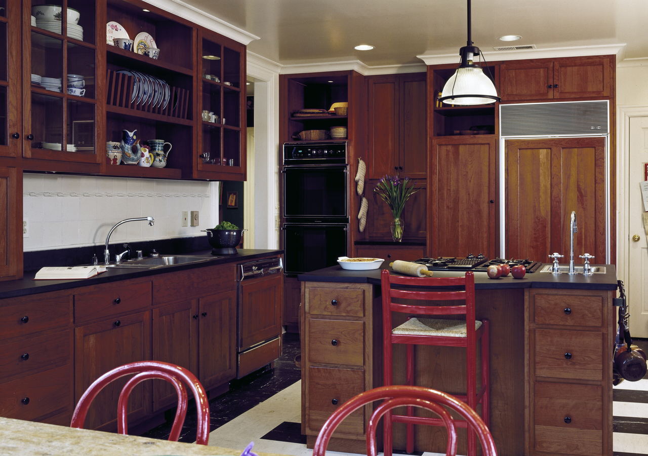 A wide modern kitchen with pale cabinets, a long island and daylight coming in from the far wall.
