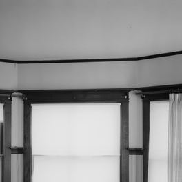Office detail: a dining room bay window seen close, sash bars and panelled reveal.
