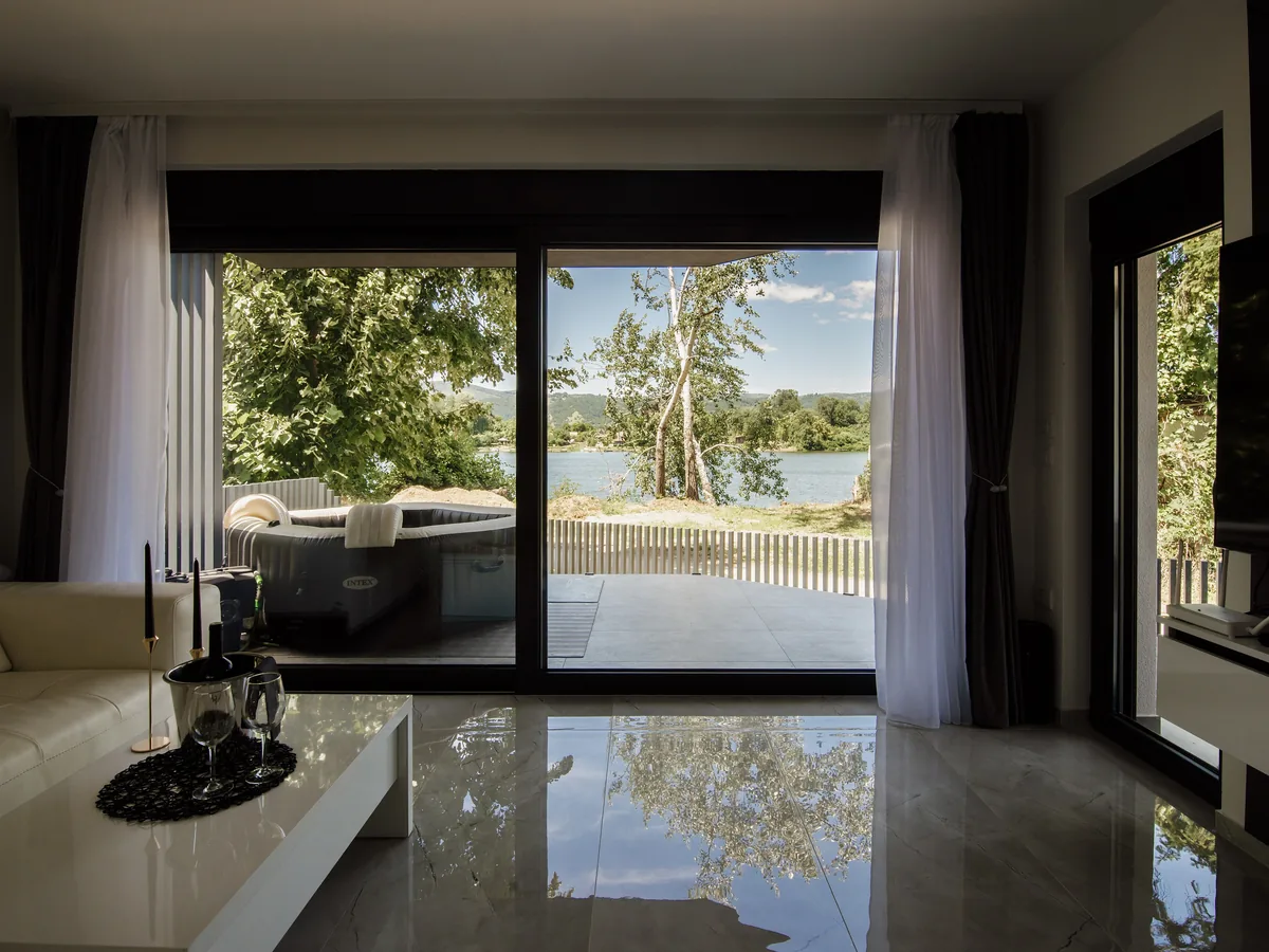 Living room with full-height sliding doors onto a lake view