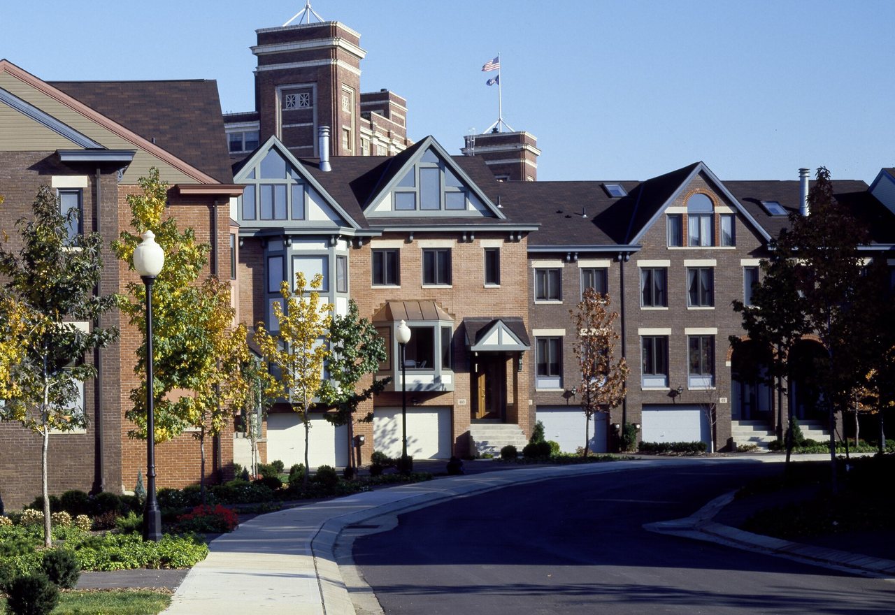 Maple Row — a brick townhome terrace with garages on a quiet curved street, Maple Ridge, OR