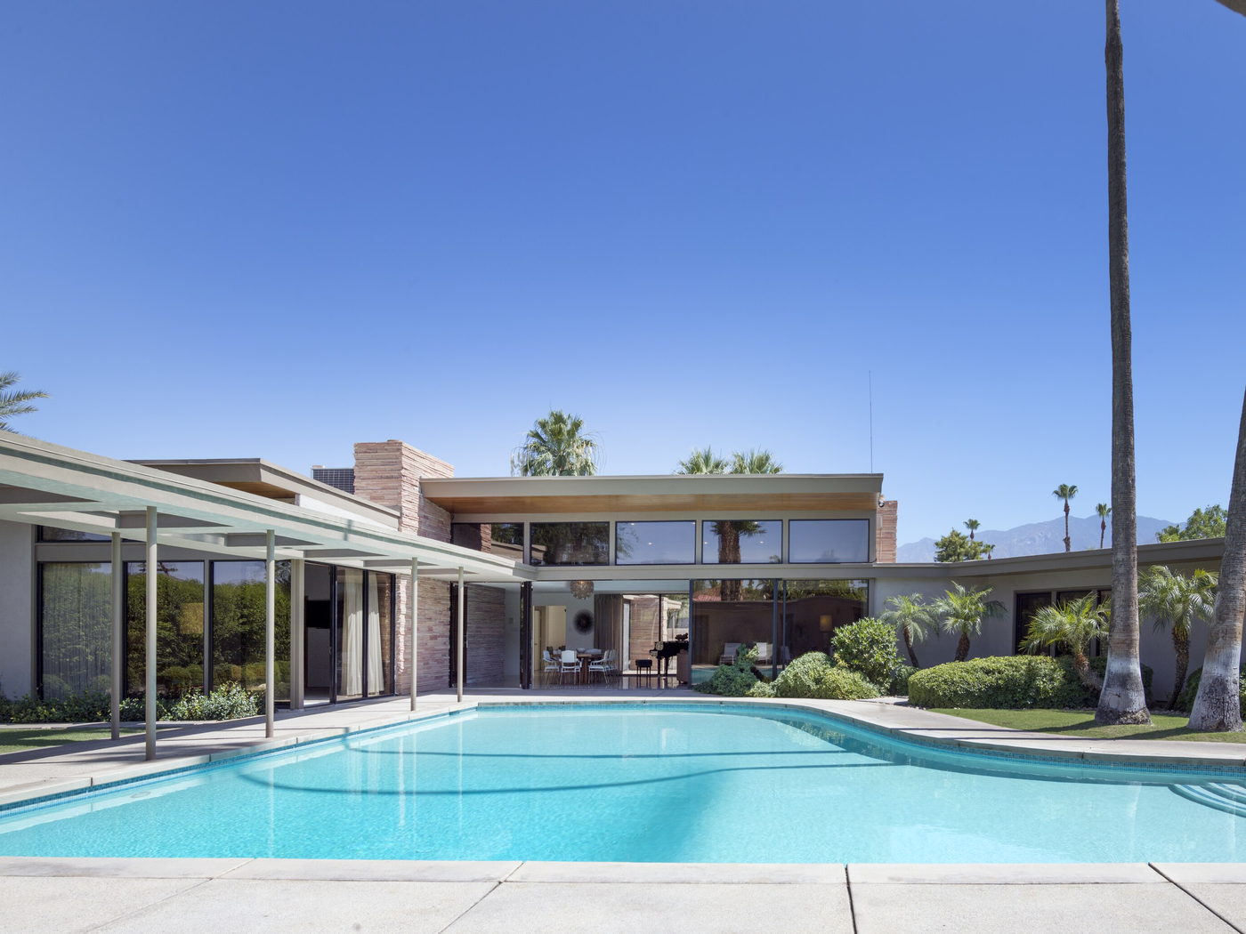 Desert-modern house with a pool and palm trees at golden hour