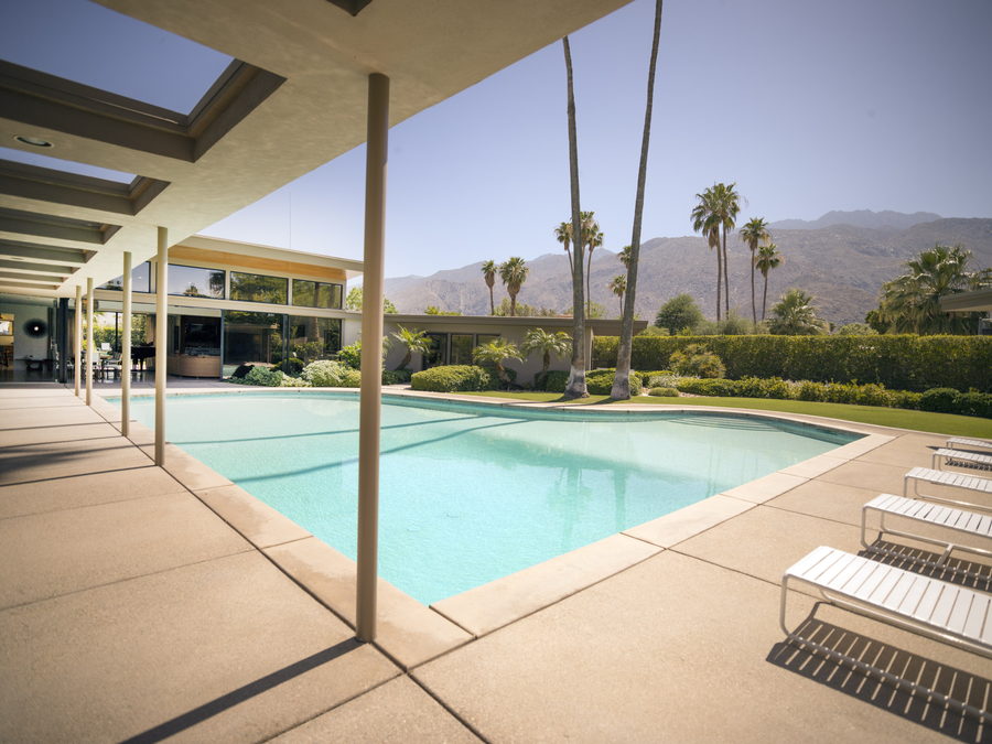 Desert-modern house with pool, palms and mountain backdrop