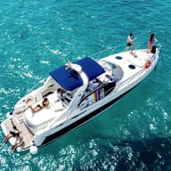 A white motor yacht on turquoise water, seen from above.