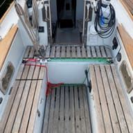 The teak cockpit and companionway of a small sailing yacht.