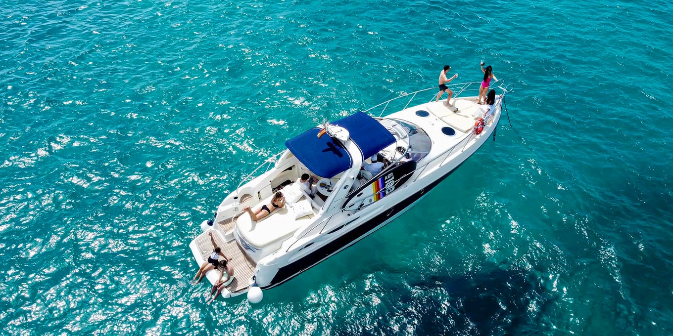 A motor yacht photographed from directly above on clear turquoise water.
