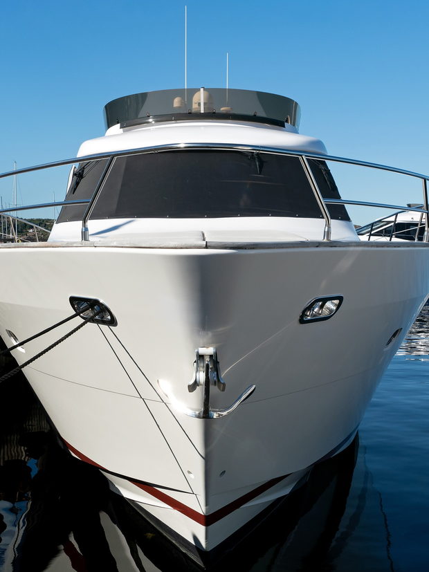 A motor yacht lying bow-on to a pontoon in a marina.