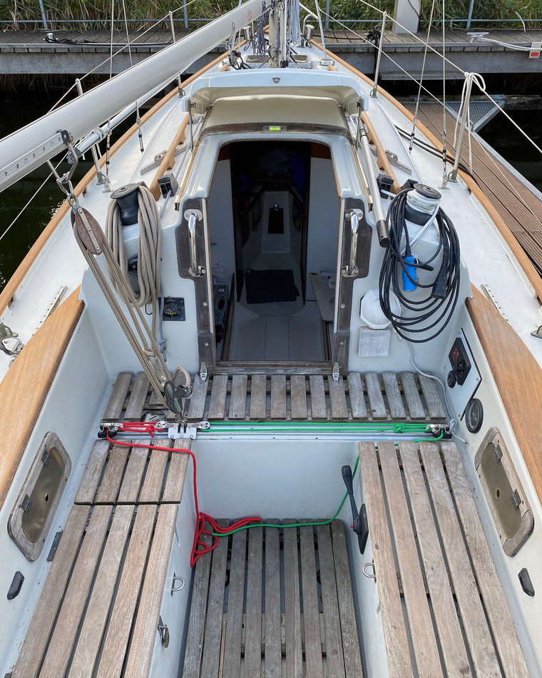 The cockpit and companionway of a small cruising yacht seen from the boom.