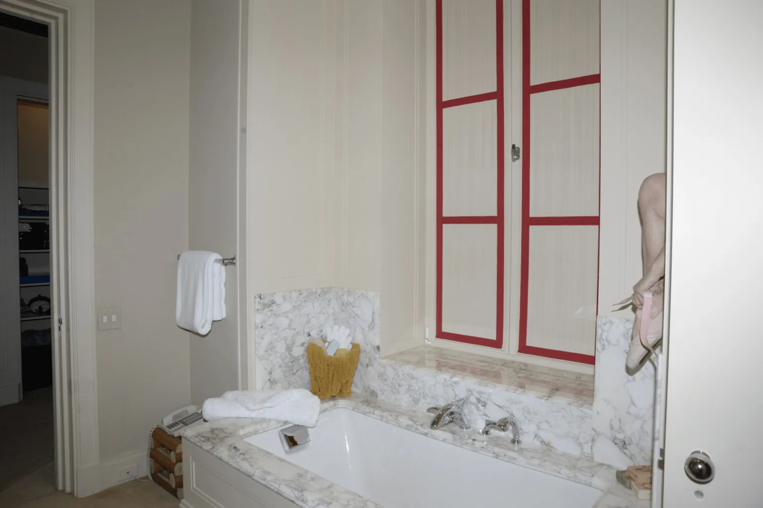 Bathroom with folded towels set out beside a wiped tub surround