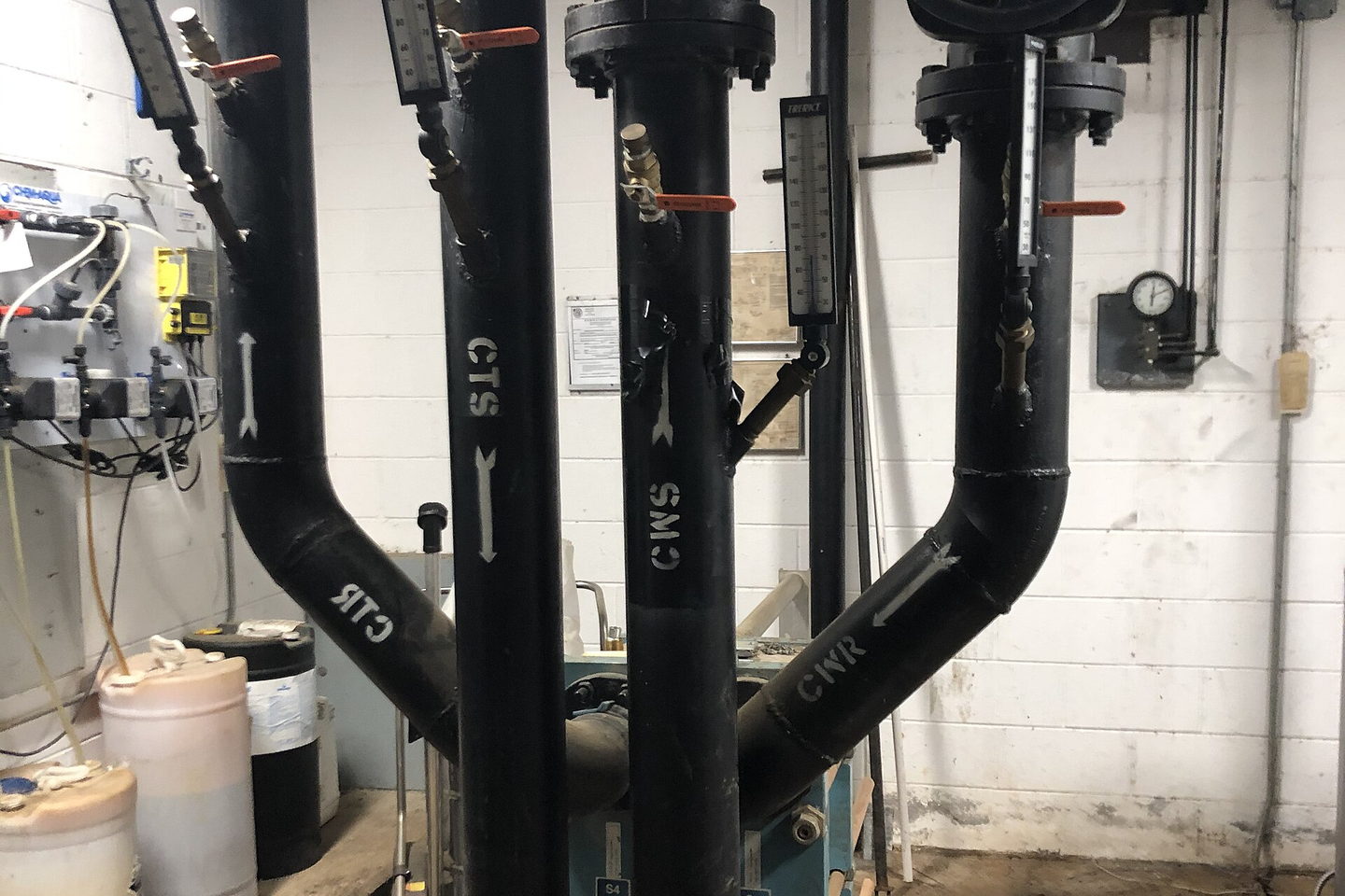 Pipework entering the head of a shell and tube heat exchanger, flanged and bolted at every joint.
