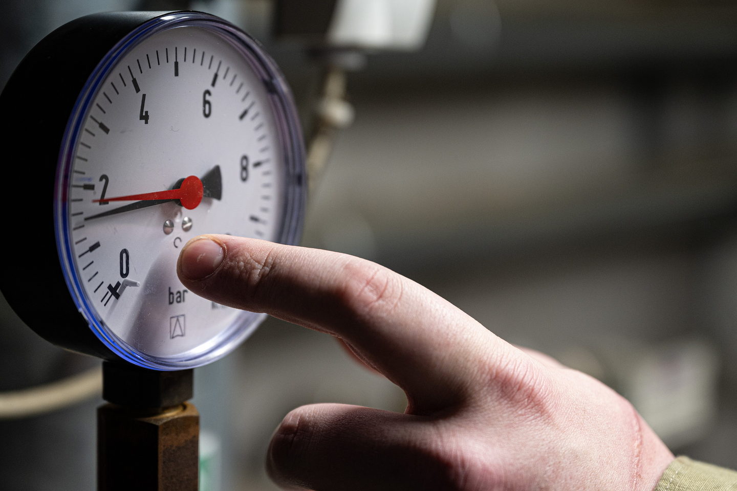 A close view of a pressure gauge on a plant line, its needle resting just above zero bar.