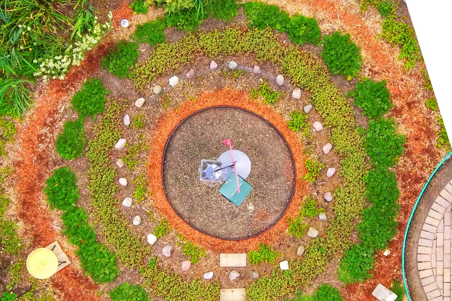 A circular ornamental bedding scheme seen from directly above, its rings of low planting and gravel laid out around a centre.