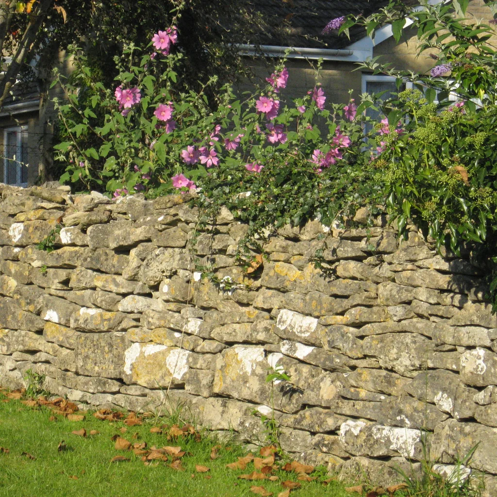 A stone retaining wall beside a maintained lawn