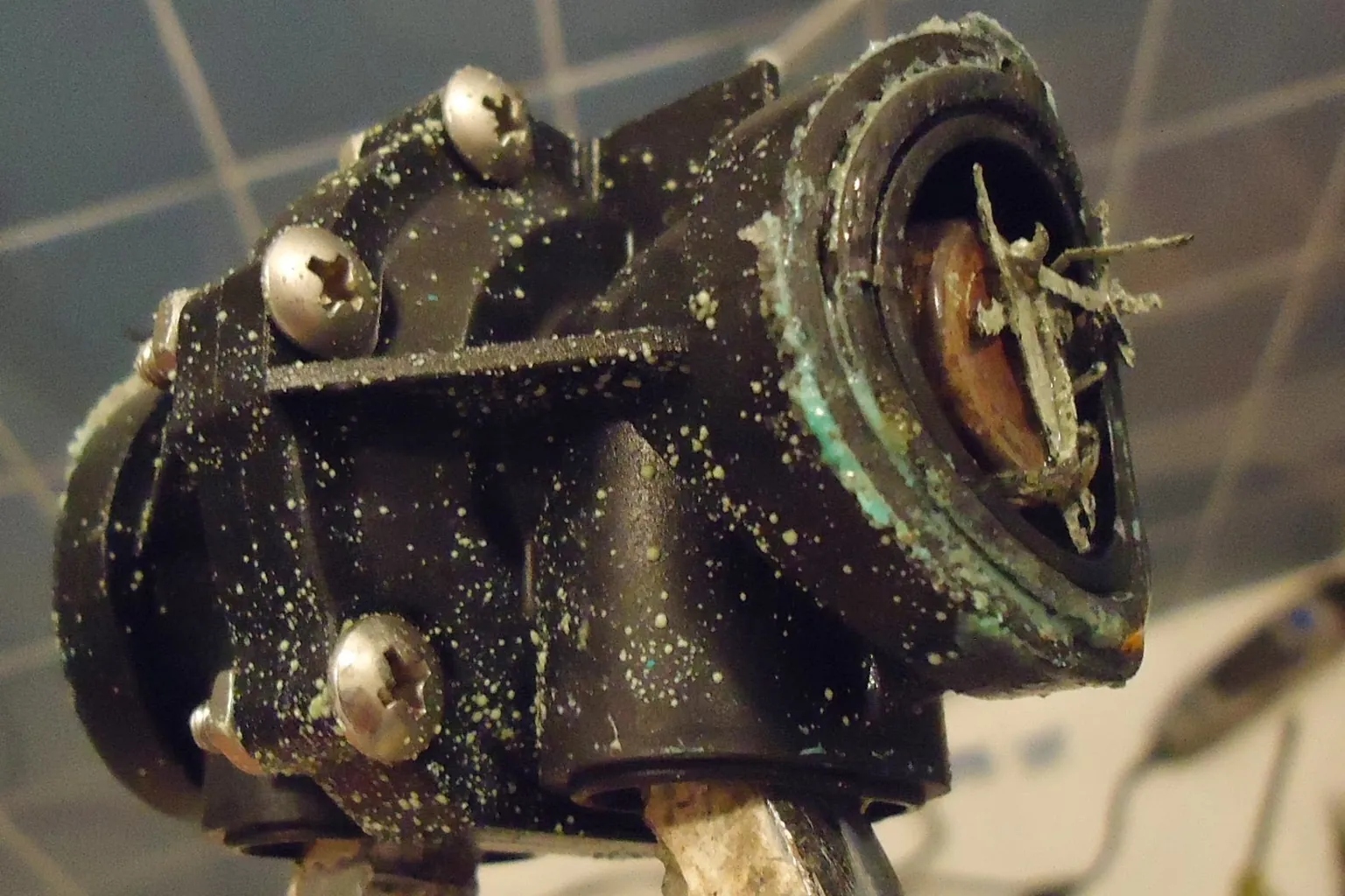 Mineral buildup on a removed shower valve body shown as evidence of wear