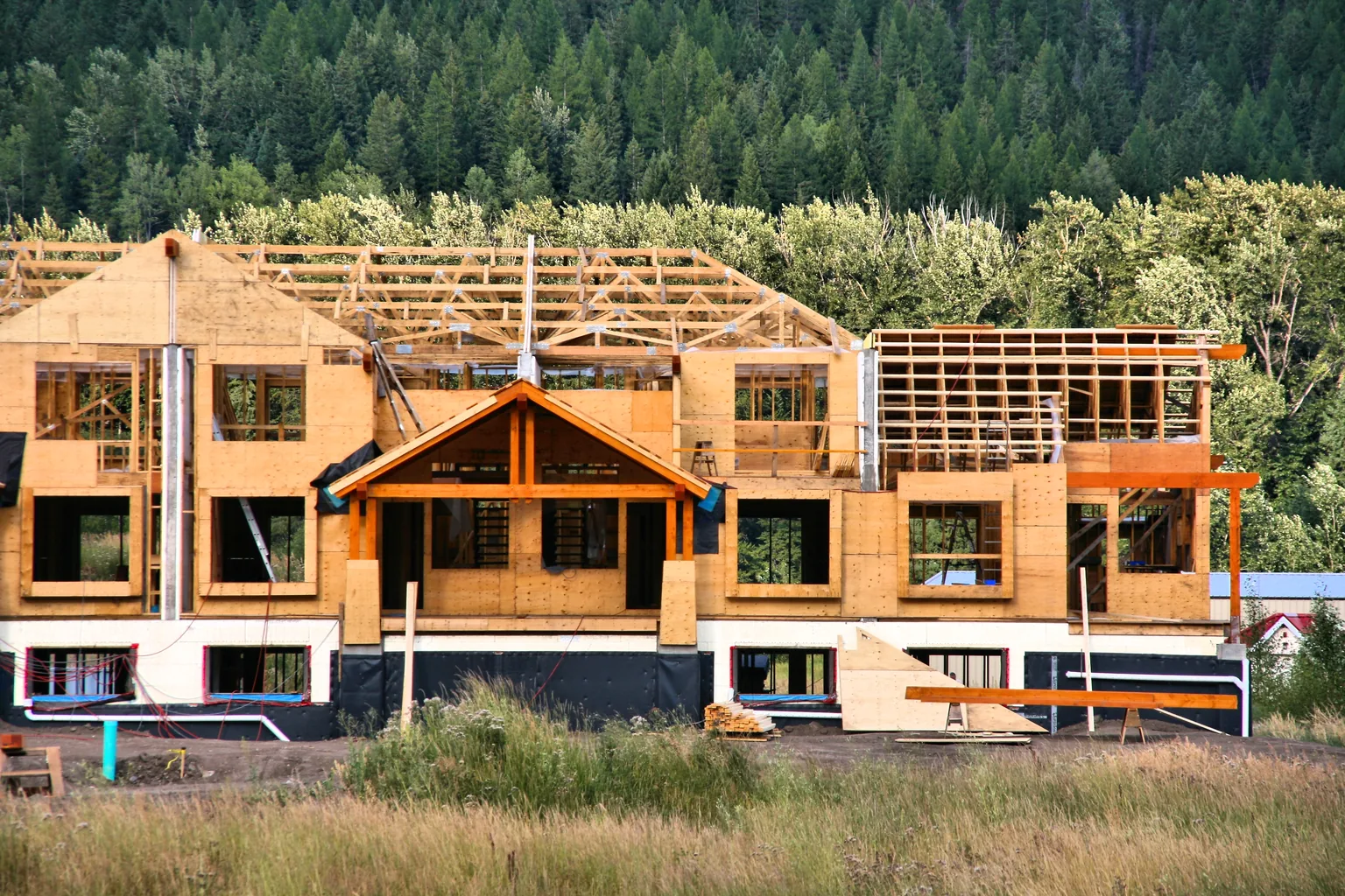 A wood-framed house part way through framing and sheathing