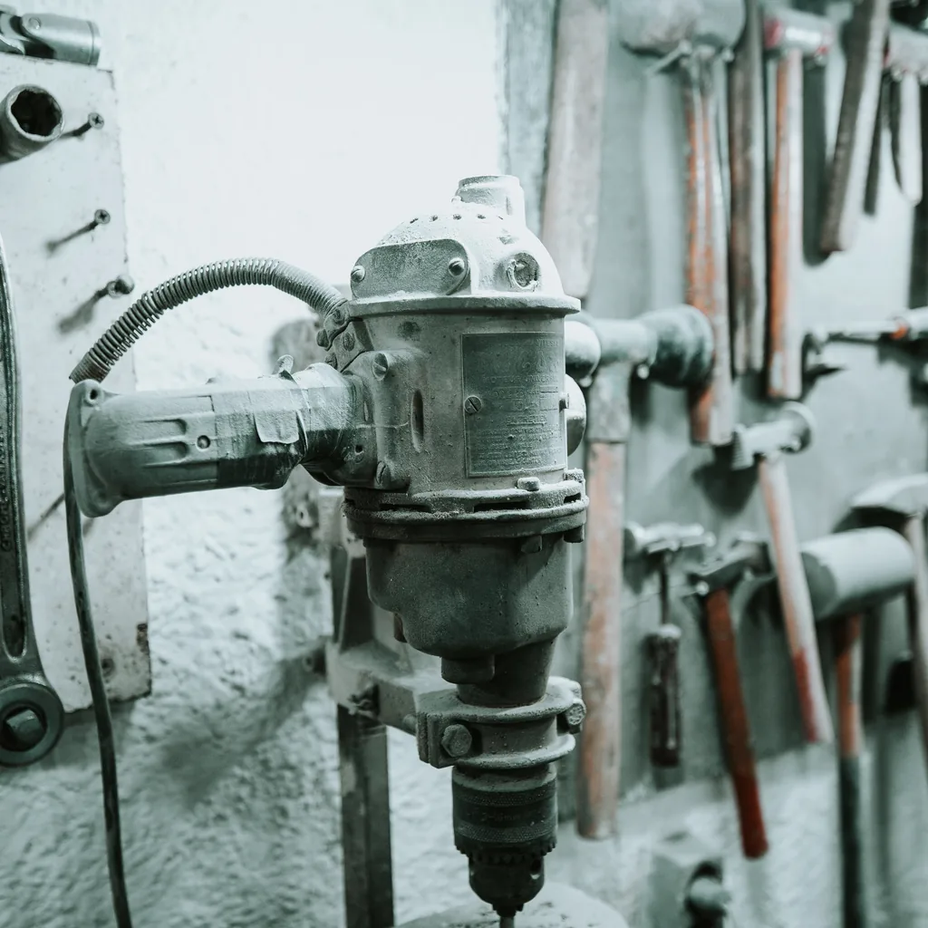 Close view of workshop bench machinery and a hand-tool rack.