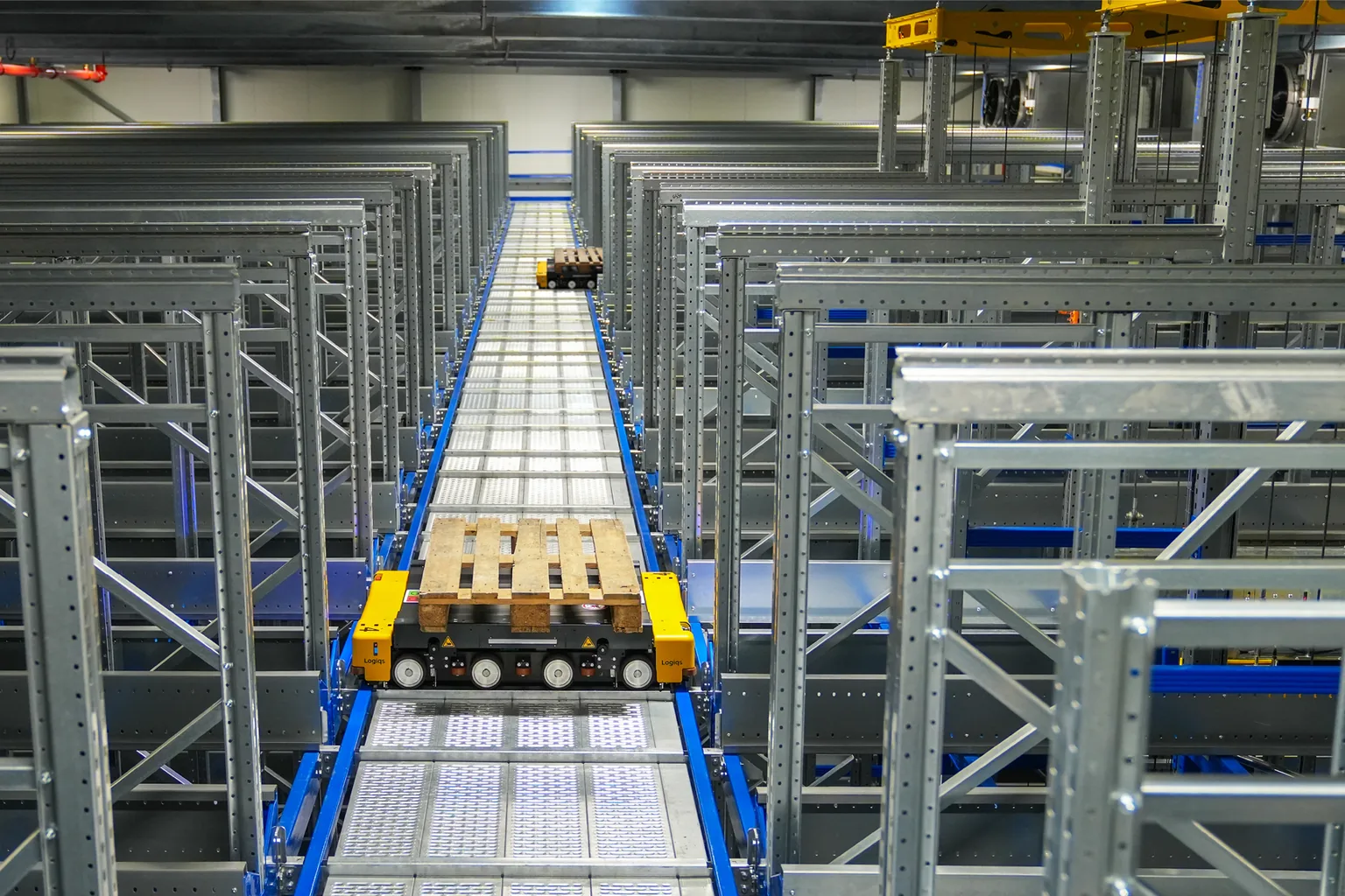 Racked storage bays with a clear retrieval aisle running between them.