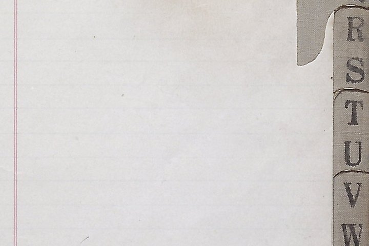 The edge of a ruled ledger page, a red margin rule down the left and a stepped alphabetical index tab running from R to W down the right.