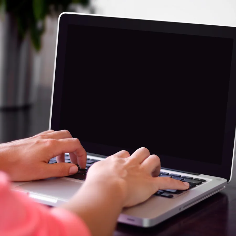 Hands typing on a laptop during a working session
