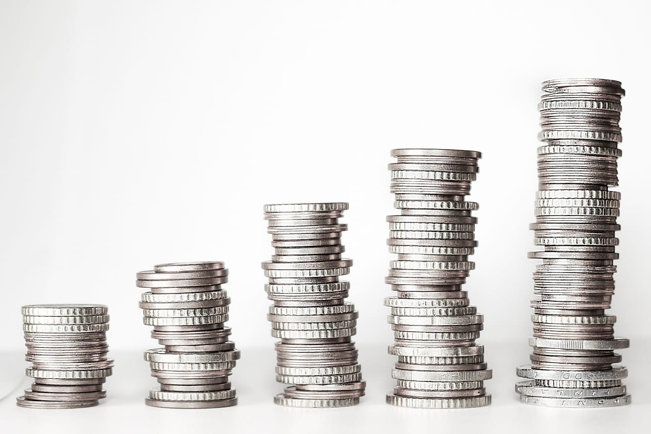 Stacks of coins rising in height across a table.