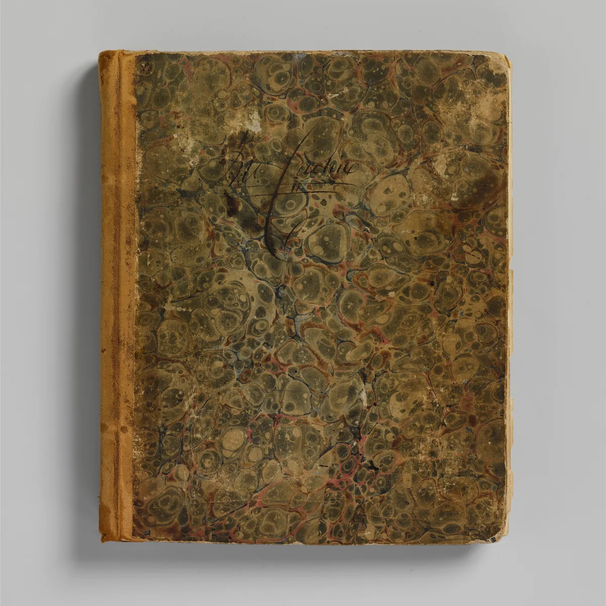 A worn hardback ledger closed on the desk