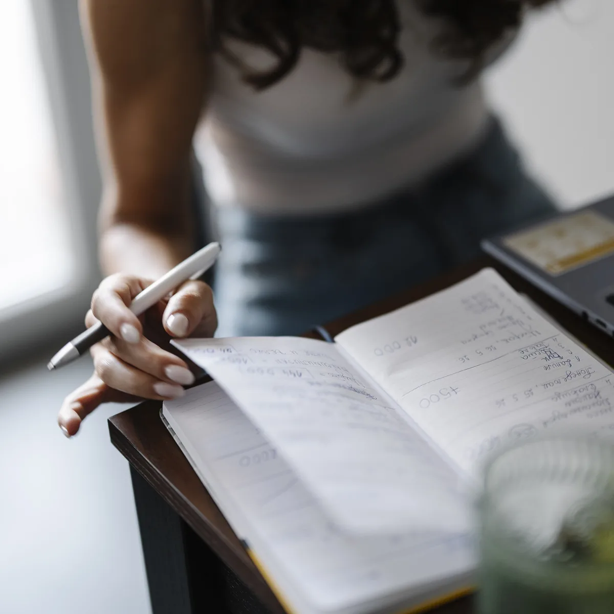 Notes being written into an open notebook at a desk