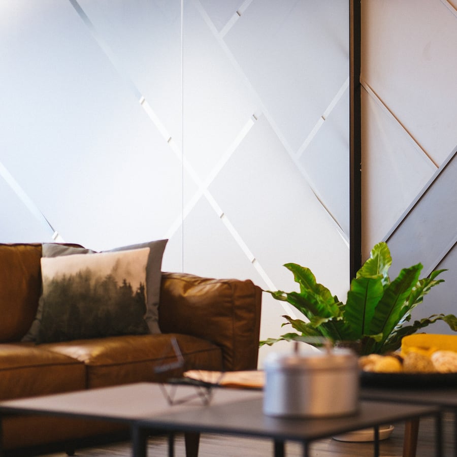 A warm meeting corner — a leather sofa, a plant and a low table
