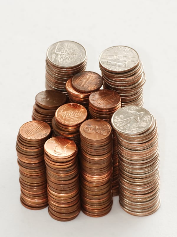 Stacks of coins of different sizes on a plain background