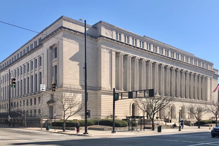 A stone courthouse rising above the street, photographed from below against an open sky.