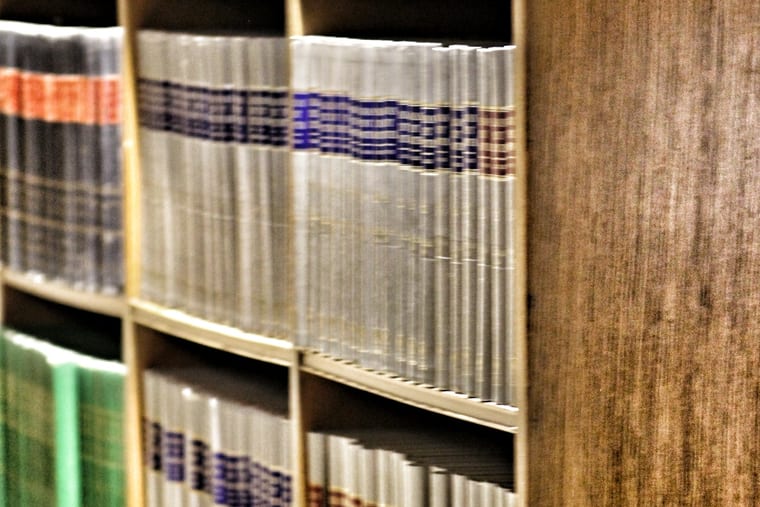 A shelf of bound law reports standing side by side, their spines numbered in gold.