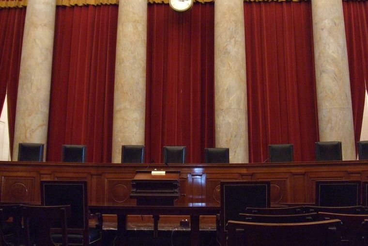 Carved panelling and the raised bench of an empty courtroom, photographed close.