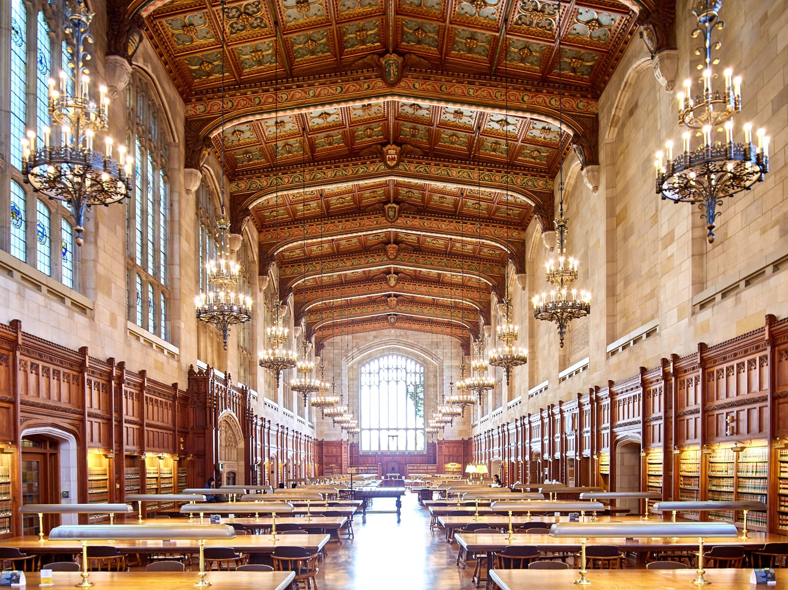 A reading room in a law library, with tiered bookcases, long tables and tall leaded windows.