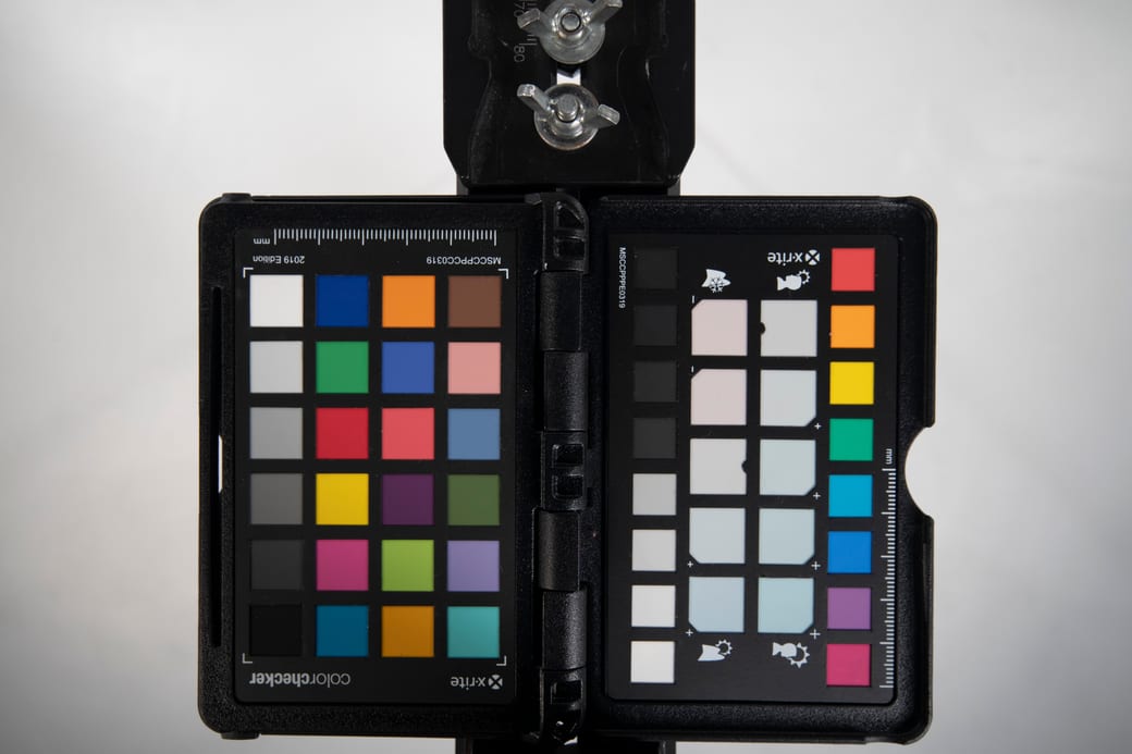 A colour-checker chart standing on a studio floor under even lighting, used to set colour before a sitting.