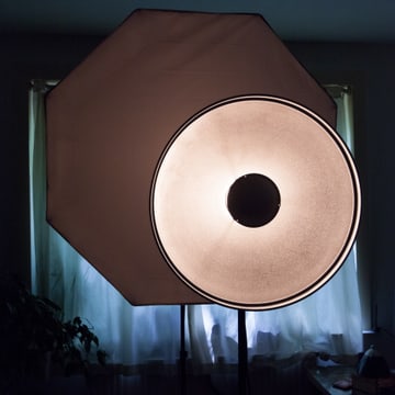 An octabox fired up on its stand, its diffusion glowing around the central deflector disc