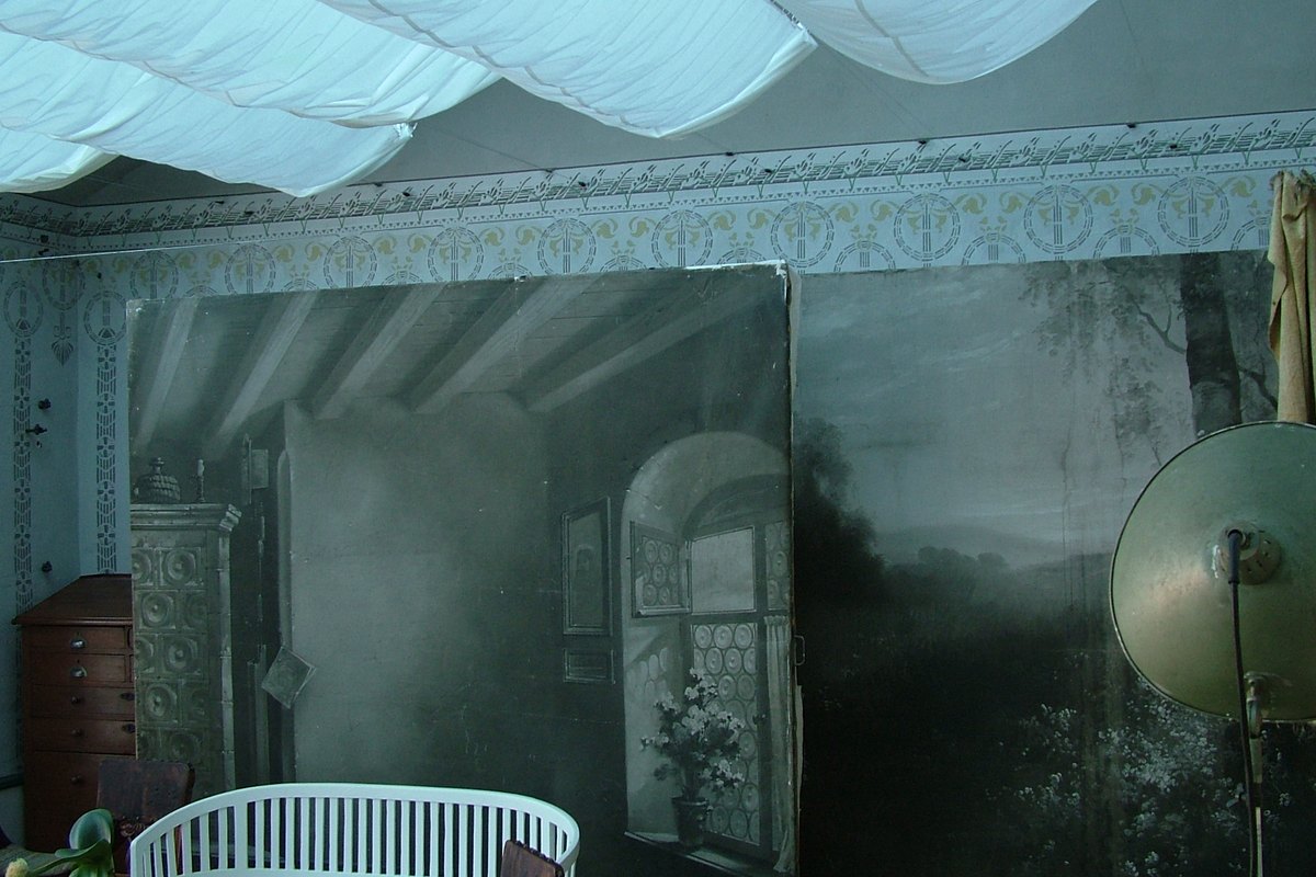 Painted landscape backdrops and a reflector lamp in a portrait studio
