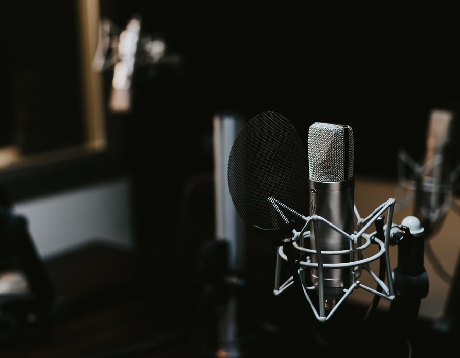 Large-diaphragm condenser microphone in a shock mount behind a pop filter