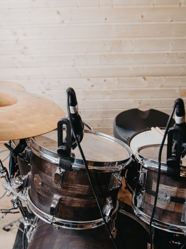 Drum kit set up and close-miked in a wood-lined tracking room