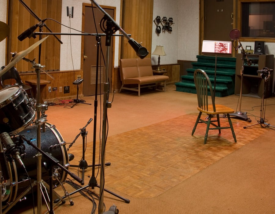 Live room with a miked drum kit, mic stands and a pop filter on a boom