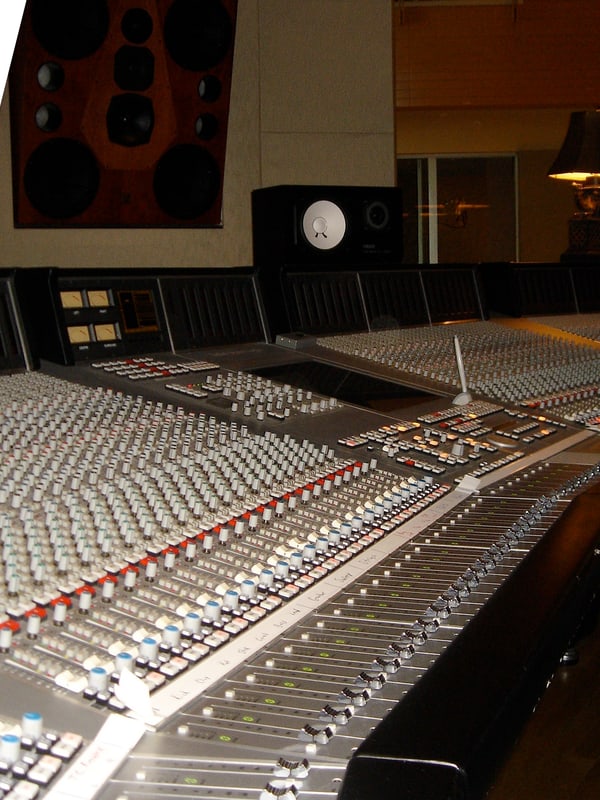 A 96-channel mixing console in a control room, monitors above the meter bridge
