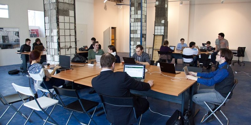 Members working at long shared desks on the open-plan floor