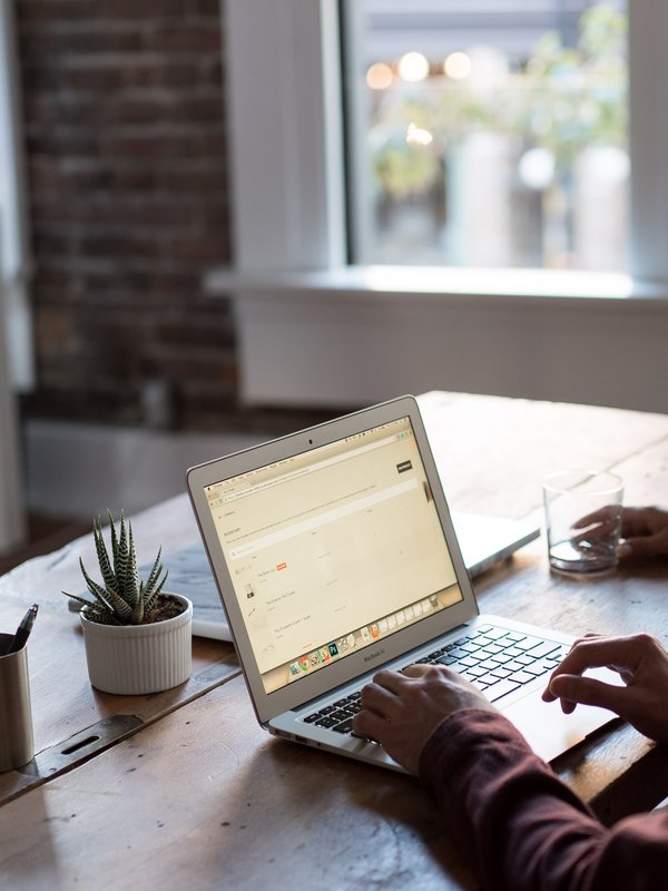 A member at work on a laptop at one of the light-filled shared tables