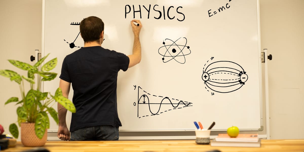 A tutor seen from behind writing PHYSICS on a whiteboard beside drawings of a pendulum, an atom, electric field lines and a damped wave.