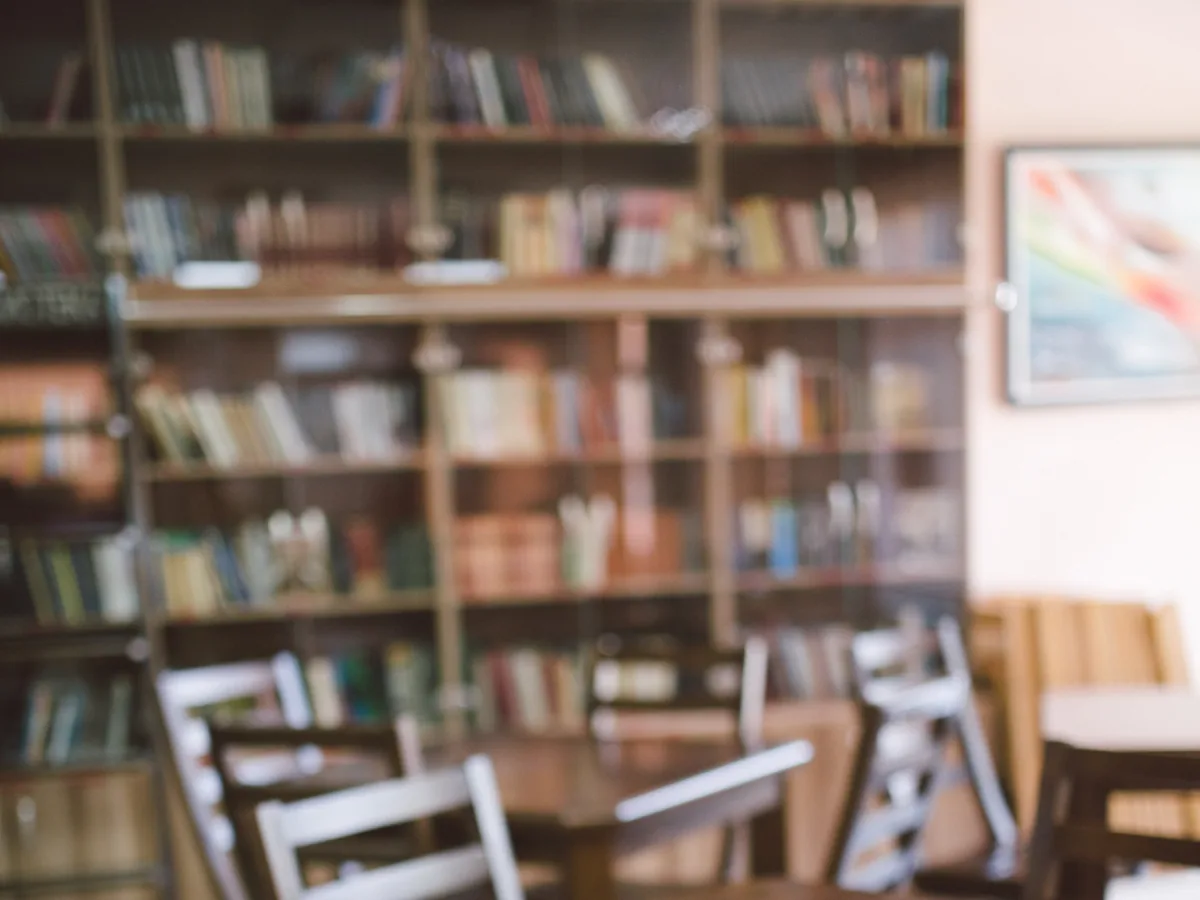 A quiet reading room with wooden study tables and full shelves