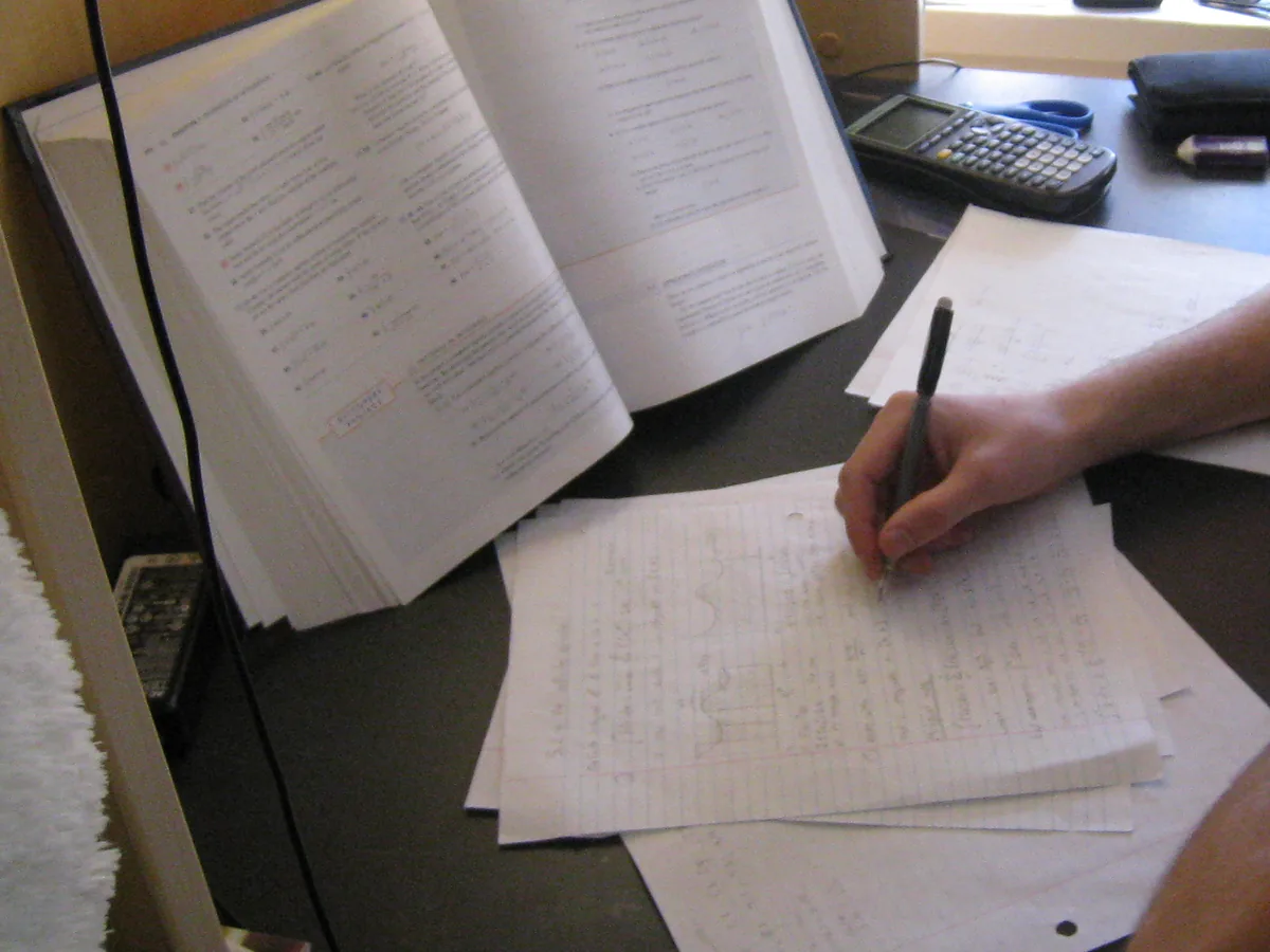Non-identifying view of a study desk with textbook and worked pages